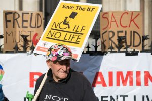 Man at protest holding NO ILF NO LIFE placard