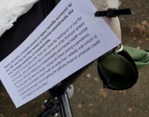 An empty purse hanging from the arm of a wheelchair