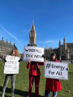 Activists from the grass roots campaign Fuel Poverty Action standing in parliament square holding 3 placards (left to right they read Cold Homes Kill, Windfall Tax Now and Energy For All