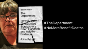 woman sits . She has brown short hair and is wearing black rimmed glasses and wearing a black t shirt. She holds a black and white book text of book says The Department How a Violent Government Bureaucracy killed hundreds and hid the evidence John Pring #TheDepartment #NoMoreBenefitDeaths